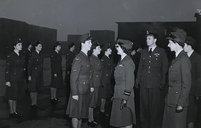 HRH the Duchess of Gloucester CI, CBE talking to a member of the RCAF WD, Gp Capt D M Edwards, the Station Commander, is in the background and Flt Off C  Muir is on the right
